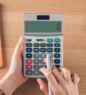 Holding a calculator and pressing buttons.