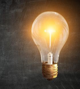 A light bulb with filament lit up.