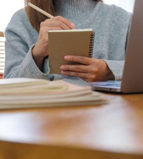 Woman writing notes in a notebook.